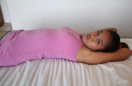 Asian amateur Shakira strips to display her hairy pussy & tits on the bed
