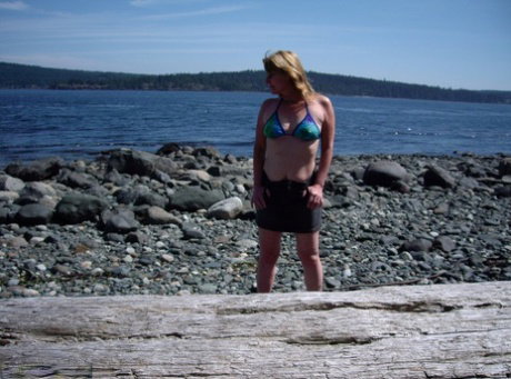 Middle-aged amateur Cougar Babe Lolee removes her bikini on a rocky shoreline