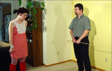 Submissive girl is caned with a crop while on all fours in red knee socks