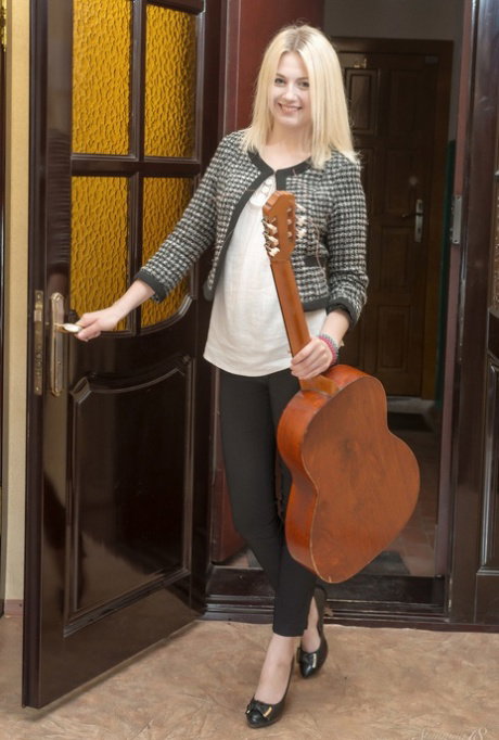 Young blonde is caught topless in her bedroom while playing the guitar