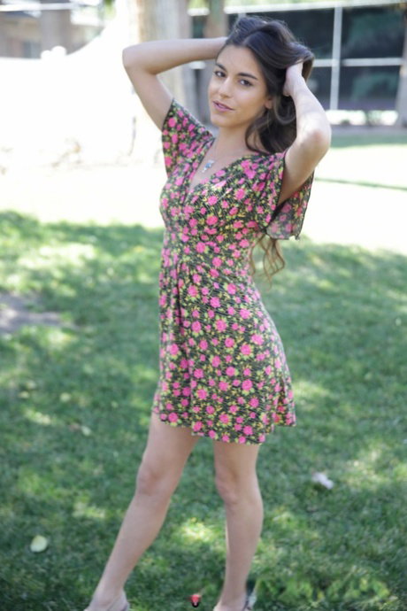 Smiley teen Arielle Faye strips down naked at garden and shows hungry pussy