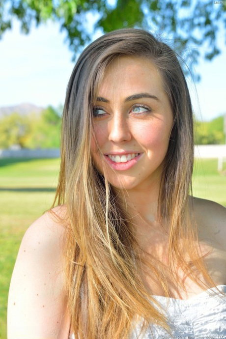 Sweet teen with lusty eyes Lacey flashes her cunt while posing in the park