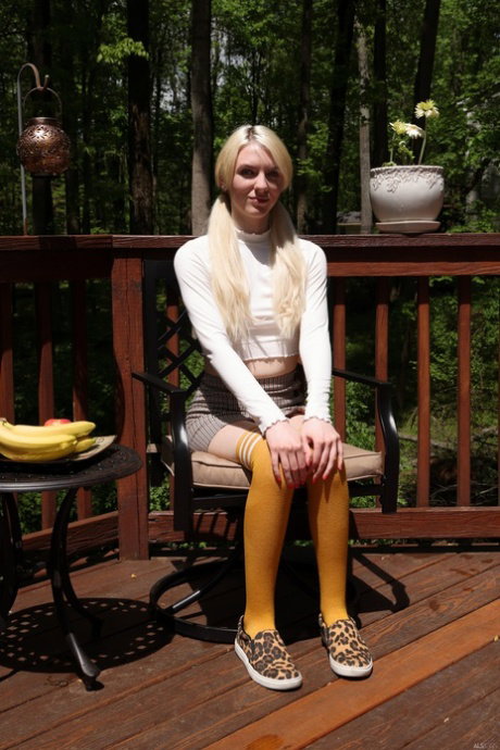 Dirty blonde Celestina Blooms sticks a cucumber in her vagina on a deck