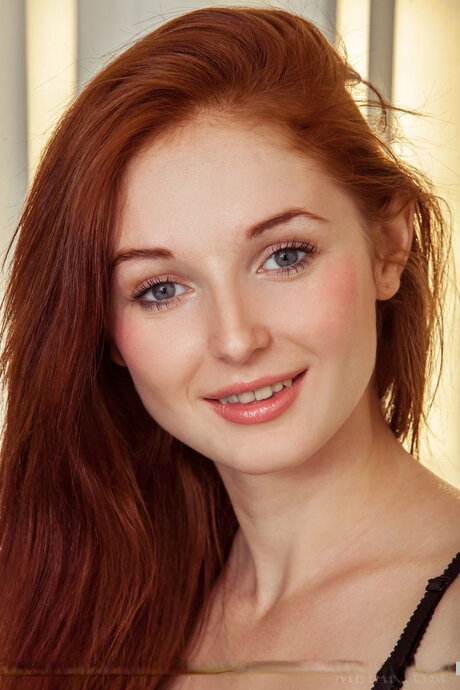 Skinny teen Leona Honey doffs black lingerie to pose naked in a well-lit room