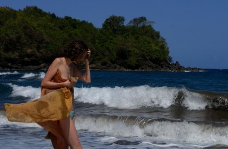 Dark haired beauty Liana gets completely naked on a volcanic beach