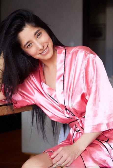 Dark haired teen Nicol Wild removes a satin robe to pose in the buff
