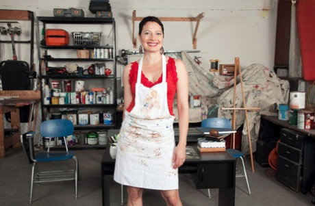 Short haired mature dame Kali Karinena doffs painter's smock to masturbate