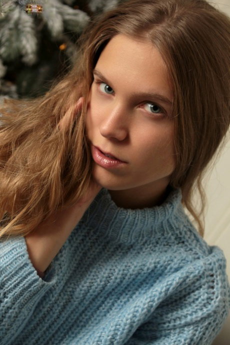 Beautiful teen Nora strips naked in front of a Christmas tree