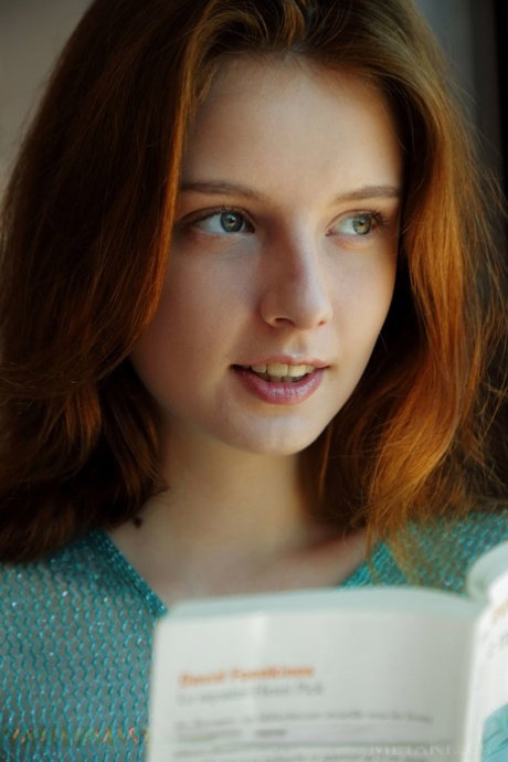 Young redhead Sienna gets totally naked on her bed after reading a book