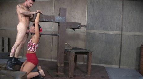 Restrained brunette London River gags on a cock during a face fuck