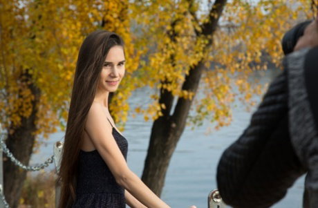 Beautiful Russian teen Leona Mia poses and goes topless at the park