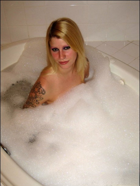 Tattooed blonde Ivy takes a bubble bath in a highly tempting manner