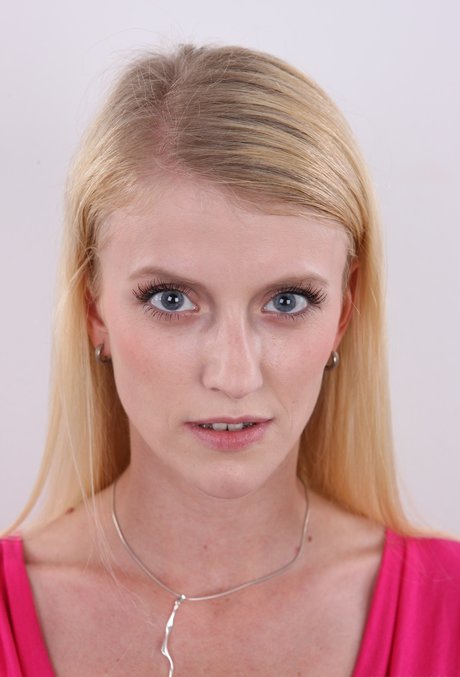 Skinny blonde with striking eyes stands naked after getting rid of her clothes