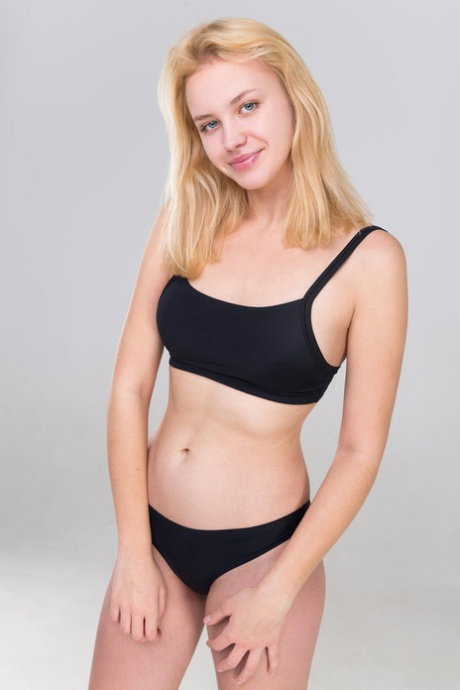 Young blonde Mandy Dee removes sports bra and panties for nude poses