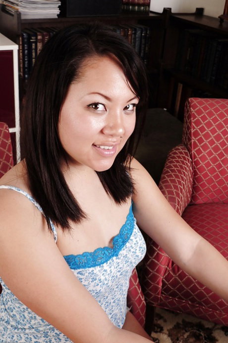 Brunette Asian Tina is being filmed in close up while wearing sexy dress