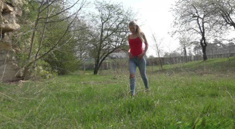 Pretty blonde Claudia Macc pulls down ripped jeans to pee up against a rock