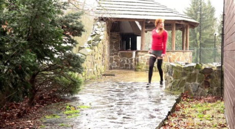 Redhead Sandra lifts her skirt to take a long hot pee in public