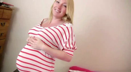 Pregnant blonde gets completely naked while alone in her bedroom