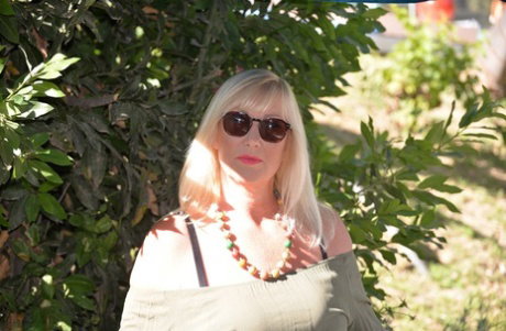 Fat blonde Melody fondles her breasts while outdoors in sunglasses