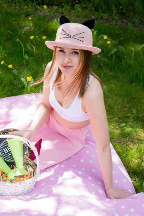 Cute teen gets totally naked on a blanket during a picnic in the park