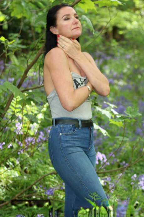 Gorgeous brunette Bettastic poses outdoors in a strapless top & tight jeans