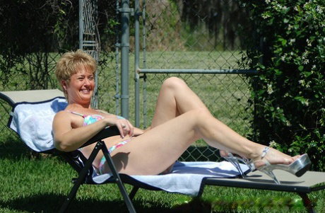 Mature amateur Tracy Lick shows off her cuddly tits & bald pussy outdoors