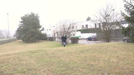 Caucasian girl pulls down her jeans while pissing on a grassy field