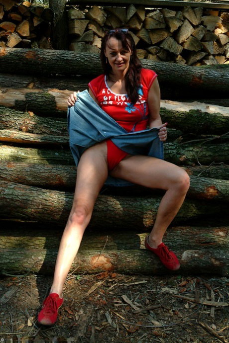 Mature slut Helga strips naked while showing her hairy pussy outdoors