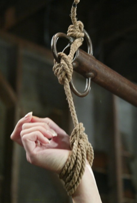 Restrained blonde Hollie Stevens endures being masturbated while suspended