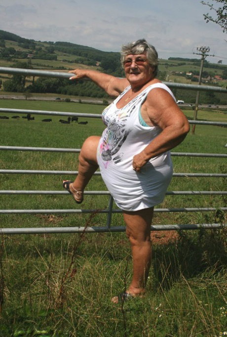 Old British woman Grandma Libby exposes herself next to a field of cattle