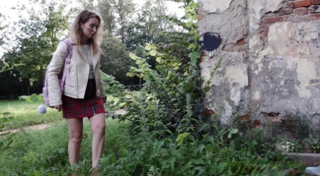 Short taken girl Rita ducks behind a building for a badly needed piss